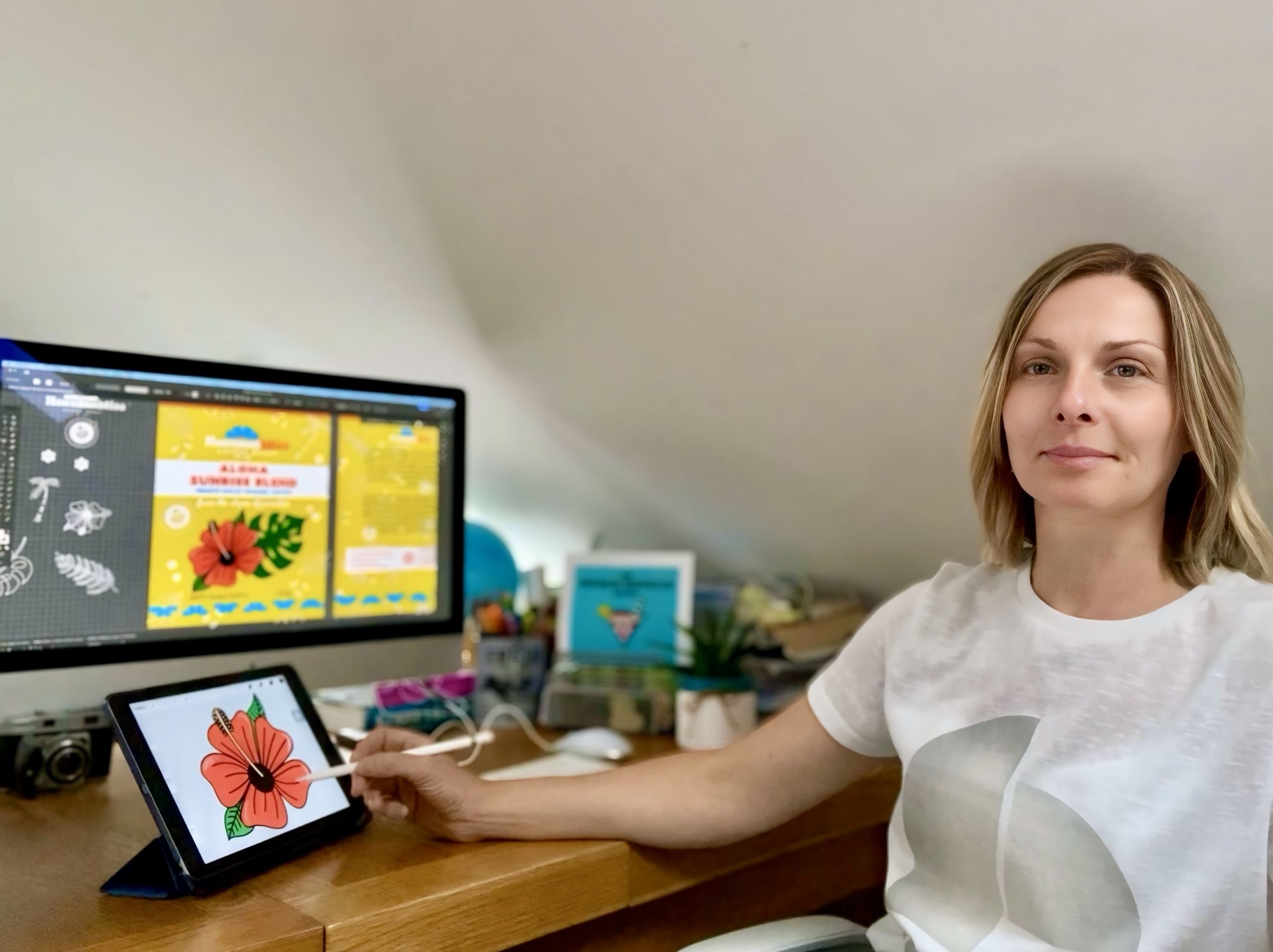 At desk Aileen sitting at her desk in her loft studio sketching on an iPad and designing a logo and coffee packaging design on MacBook
